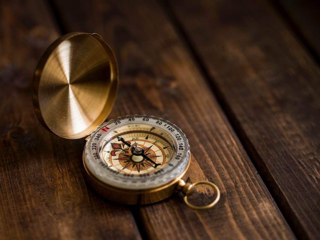 a compass on a wooden surface